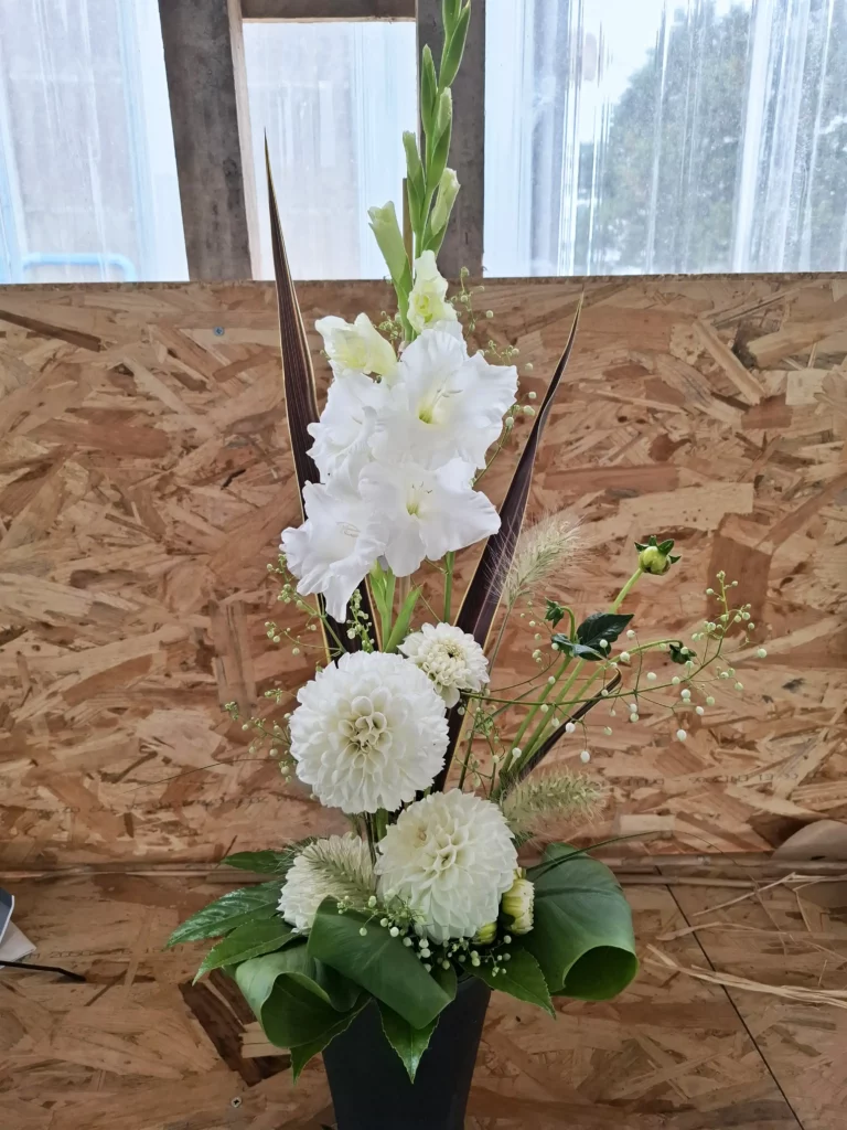 Élégante composition florale blanche avec glaïeuls et dahlias, idéale pour décor d'église ou cérémonie dans le Morbihan