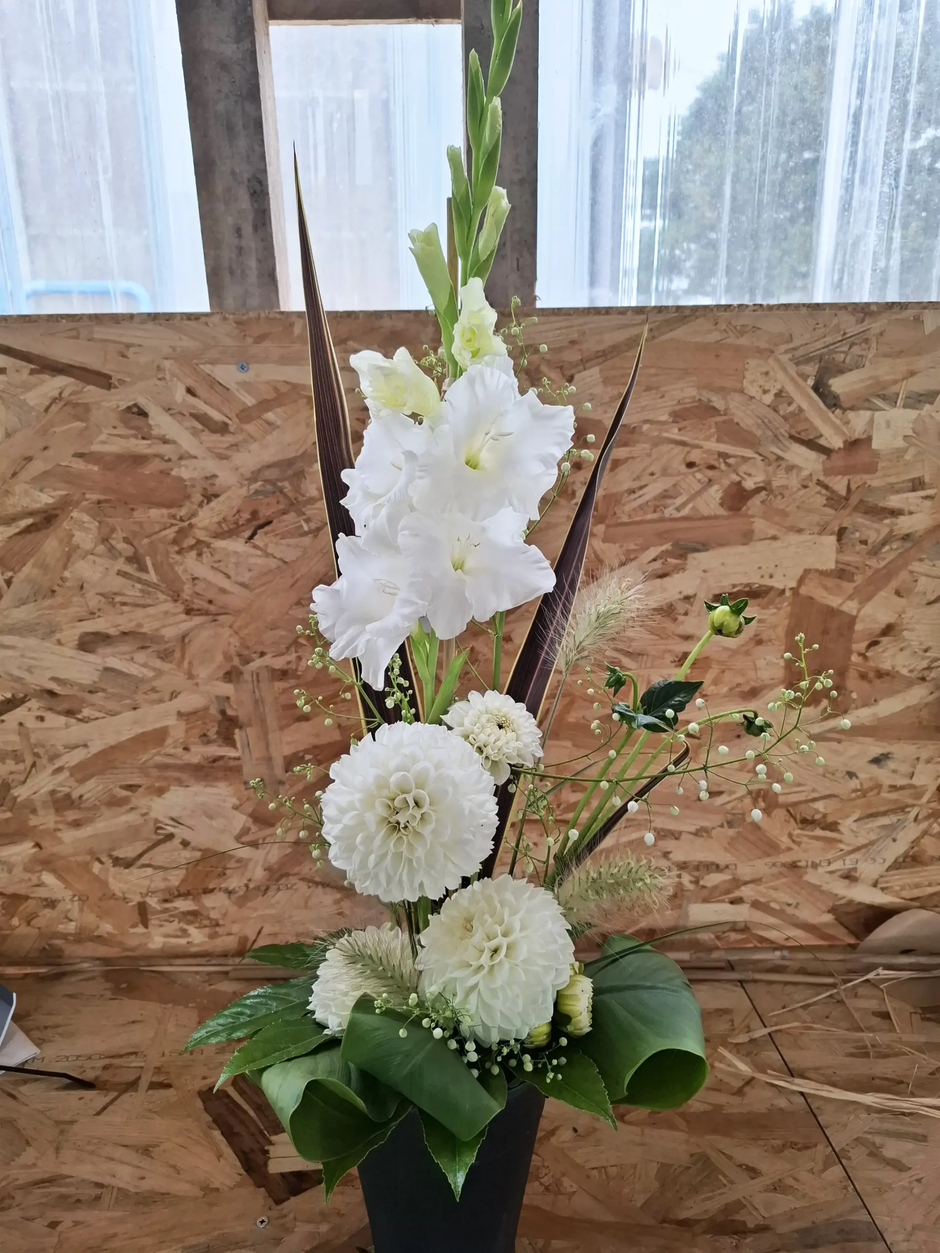 Élégante composition florale blanche avec glaïeuls et dahlias, idéale pour décor d'église ou cérémonie dans le Morbihan